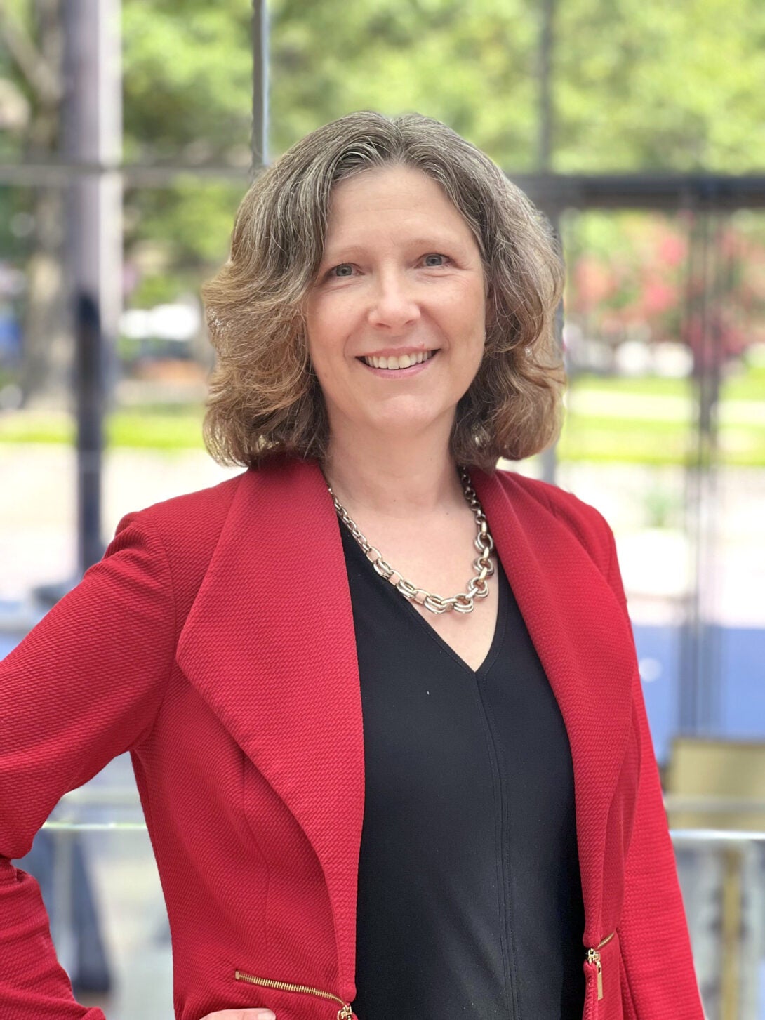 headshot of woman with black shirt and red blazer