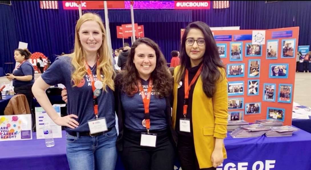 3 women standing together in front of table