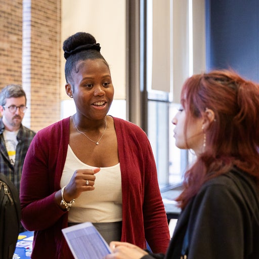 Advisor Sha'Bree Drink speaking with student at career event