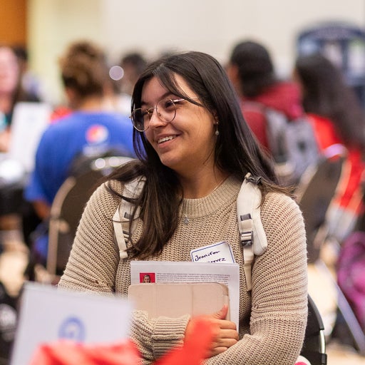 Student smiling and holding papers at career event