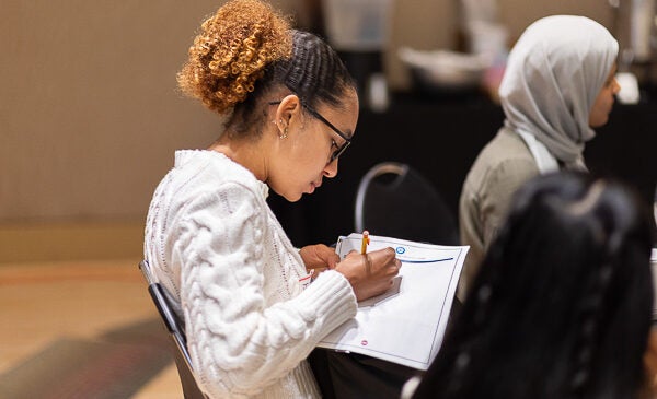 Student writes notes during healthcare event