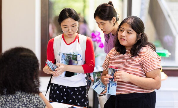 Students recieve information from table at event