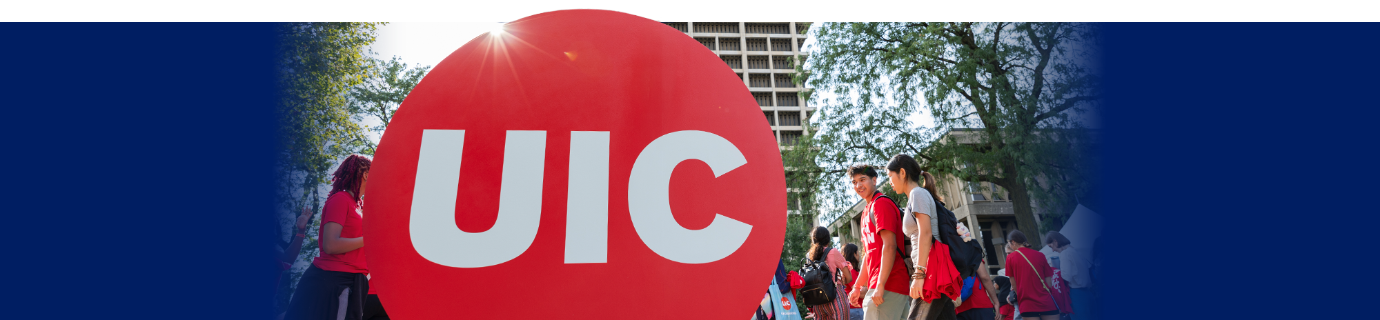 Students walking on campus during convocation with red UIC logo