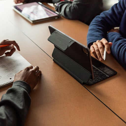 Student holding digital pen and using tablet at a desk