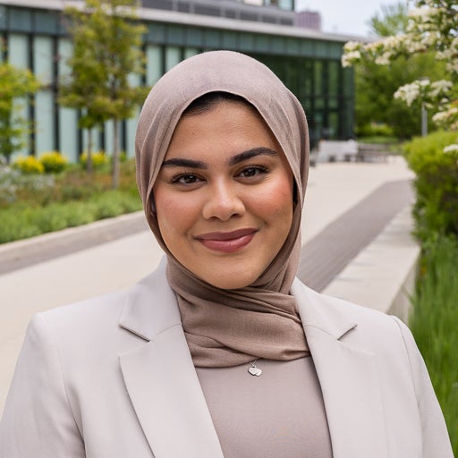 Biological Sciences student smiles on campus in tan outfit